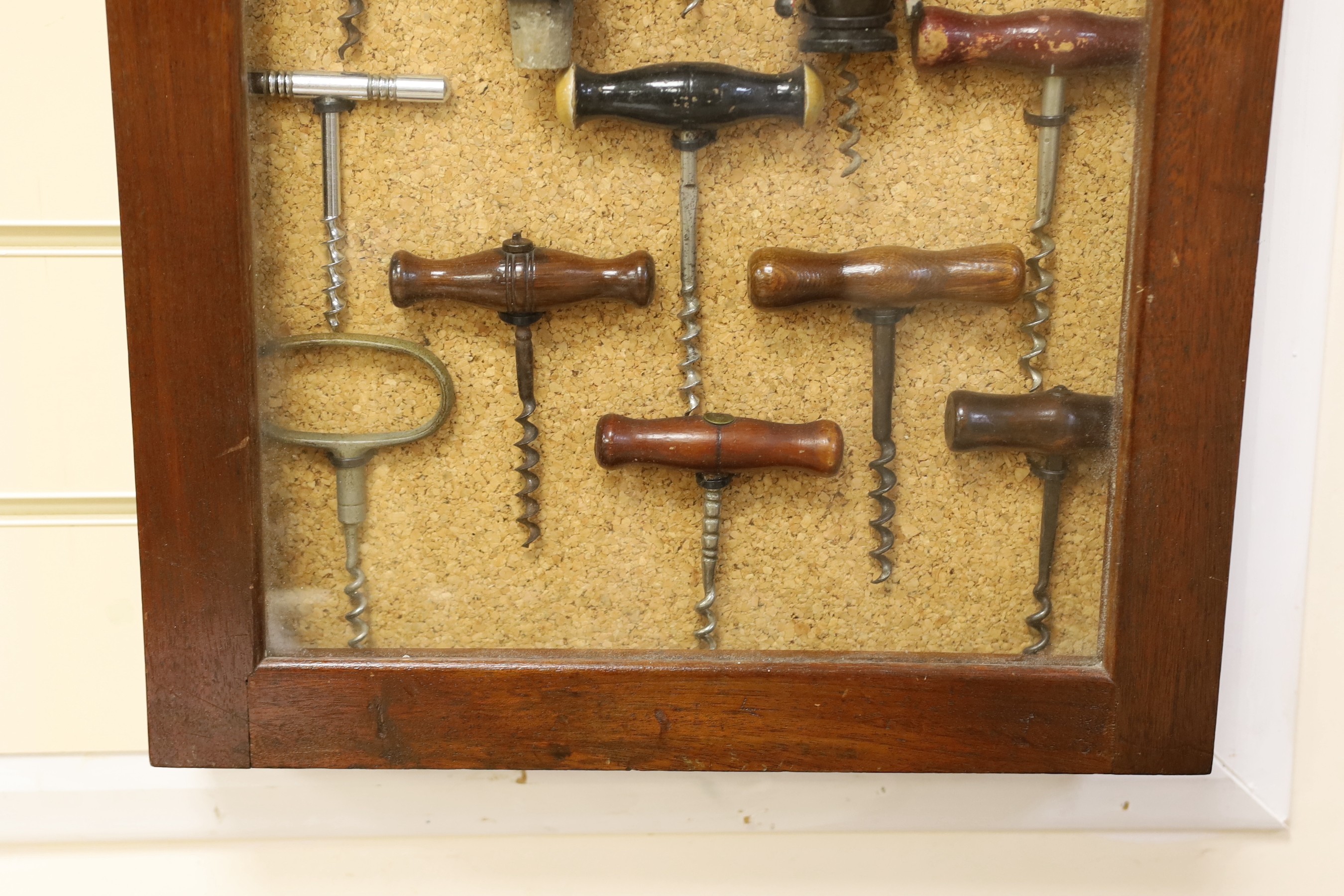 A collection of vintage corkscrews, some novelty, in glazed mahogany vase with key